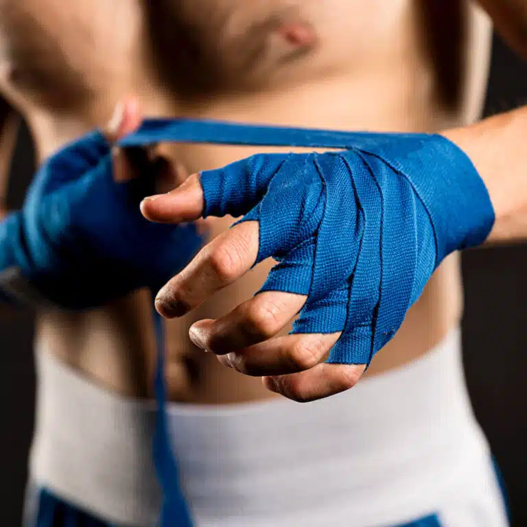 Boxer wrapping hands in blue boxing wrap