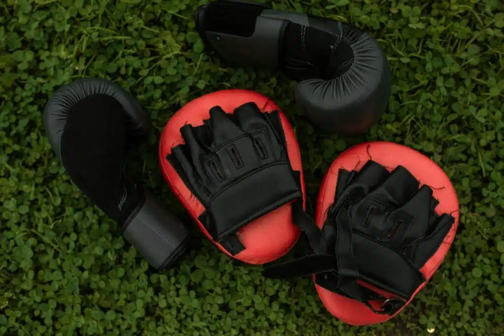 Beginner boxing gloves and pads laying on the floor