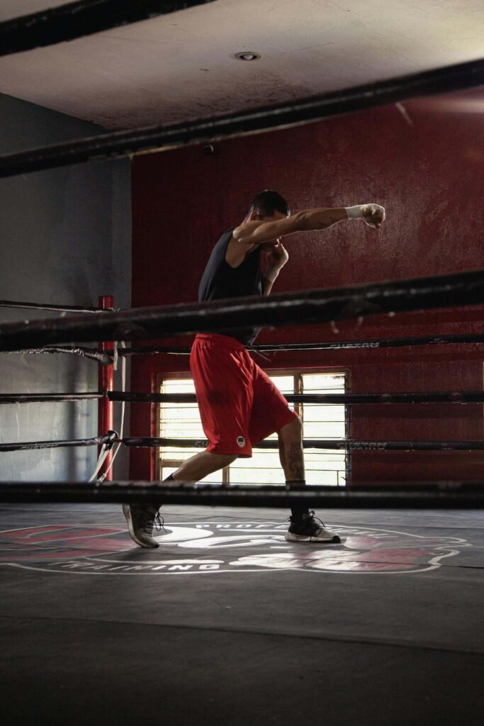 A boxer shadowboxing in a boxing ring