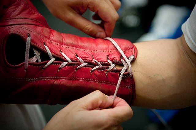 Boxer getting his boxing gloves laced up