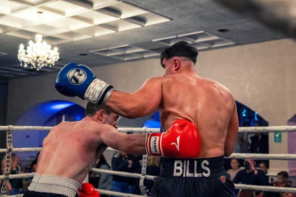 A boxer rolls his head under a hook in a boxing match
