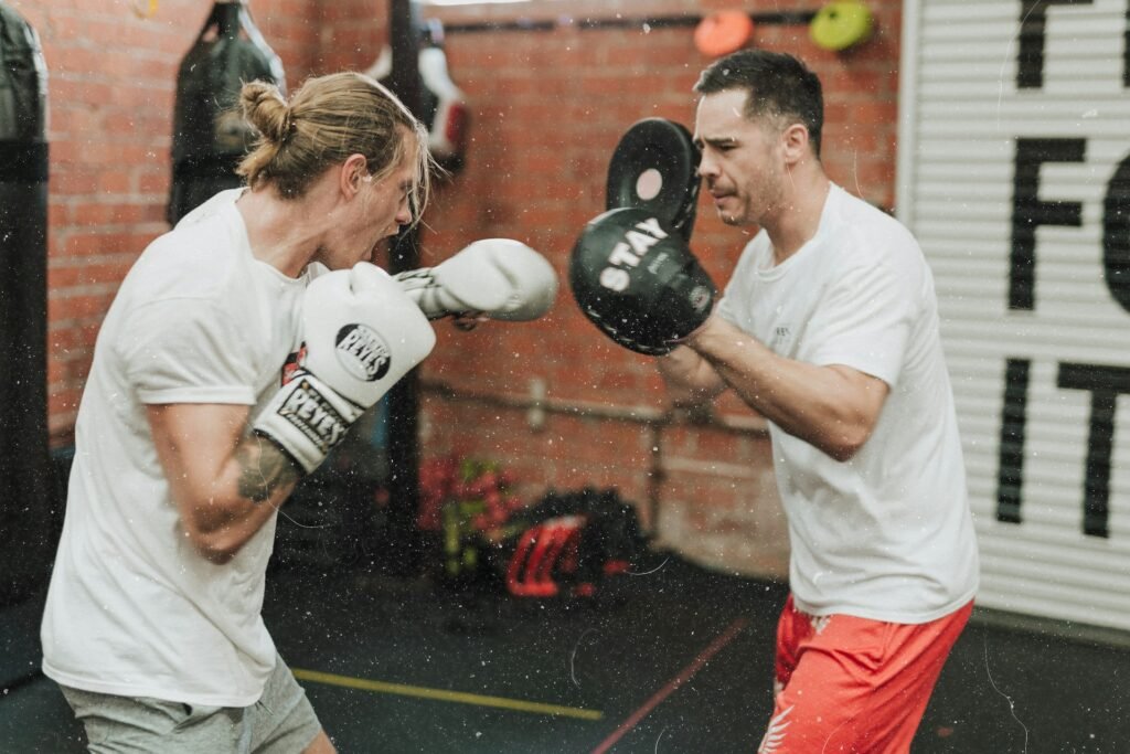 Lady practising boxing with her coach