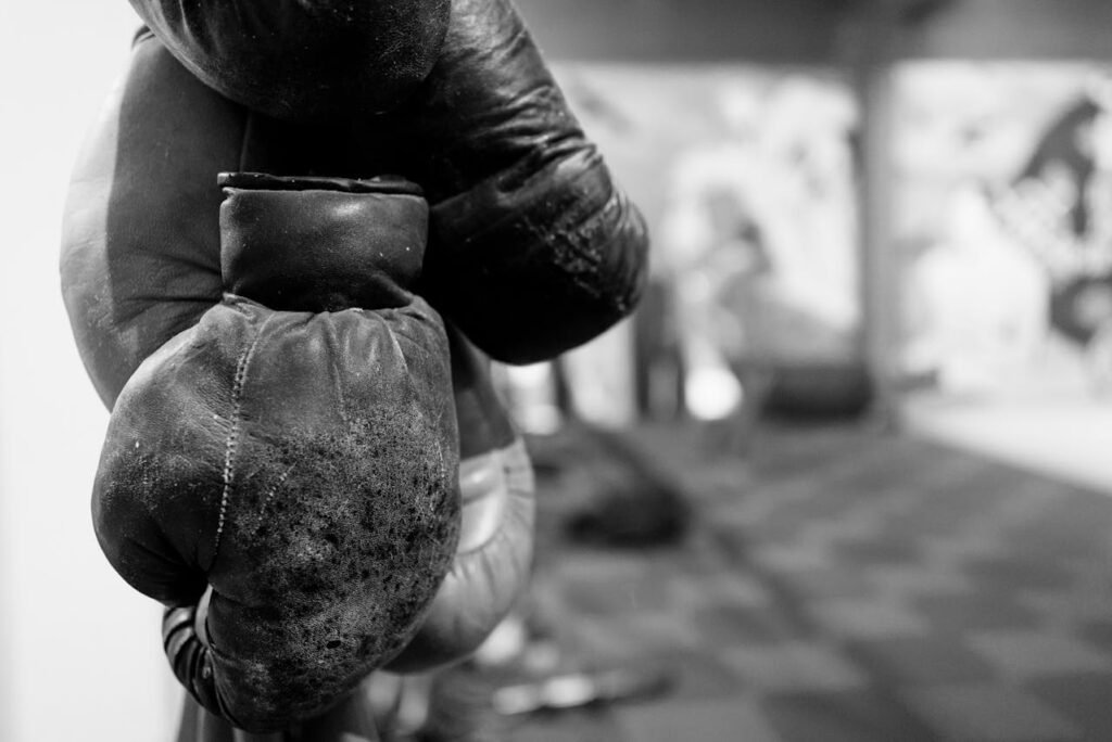 Worn boxing gloves hanging out in a gym