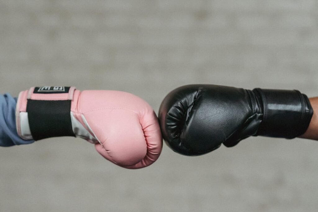 A black and pink gloves comparison of boxing glove sizing