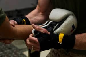 a boxer getting his boxing glove put on by his coach