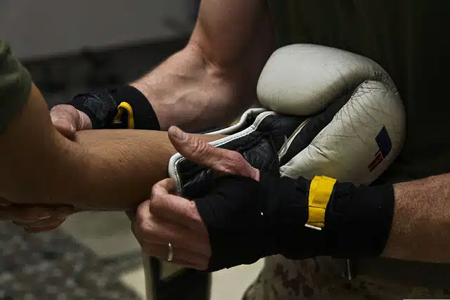 a boxer getting his boxing glove put on by his coach