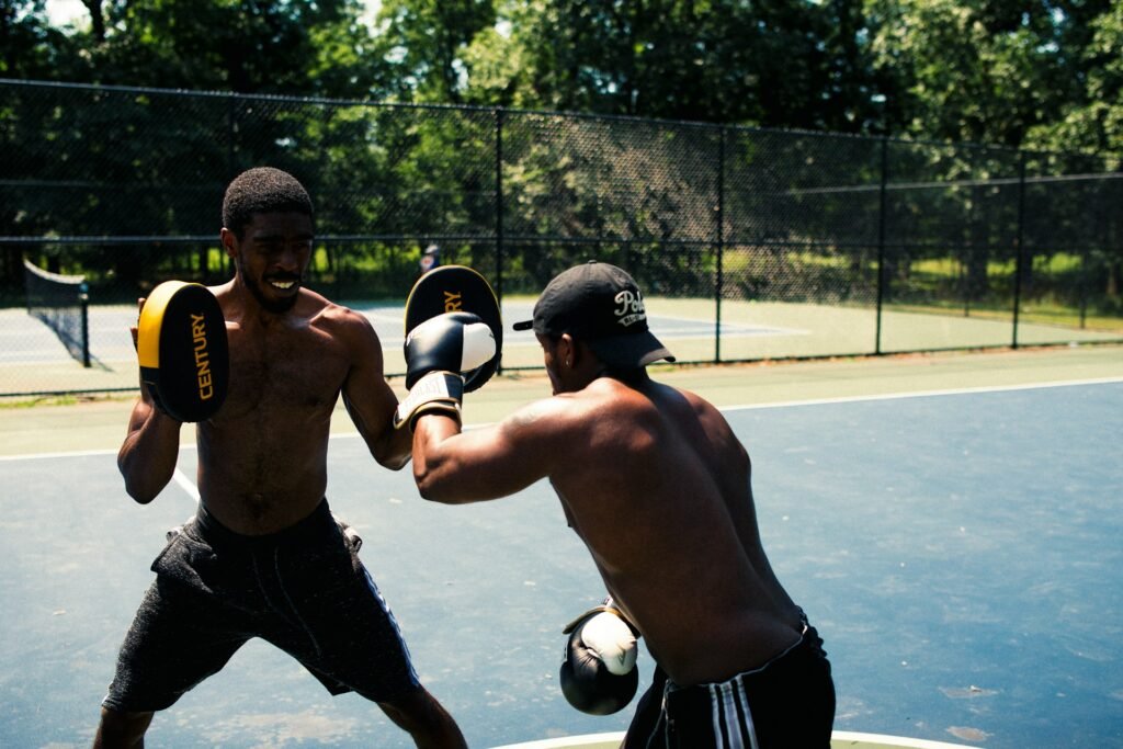 A boxer and pad man practising some boxing combinations in the park