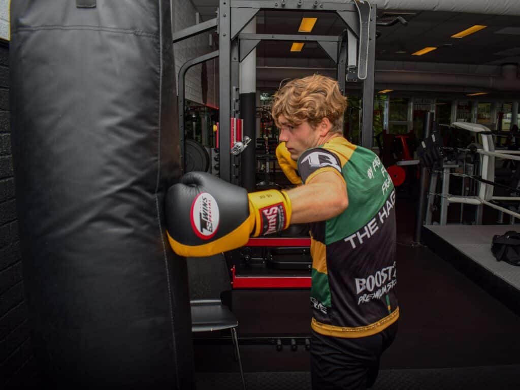 A boxer practises the beginner body hook on a heavy bag