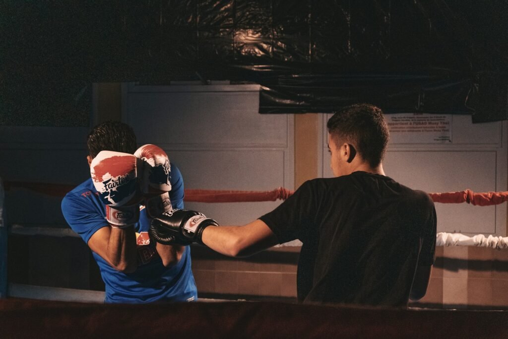 A beginner boxer tries a block in a boxing ring