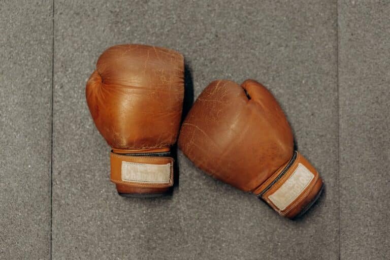 A pair of old and worn boxing gloves lay on the floor