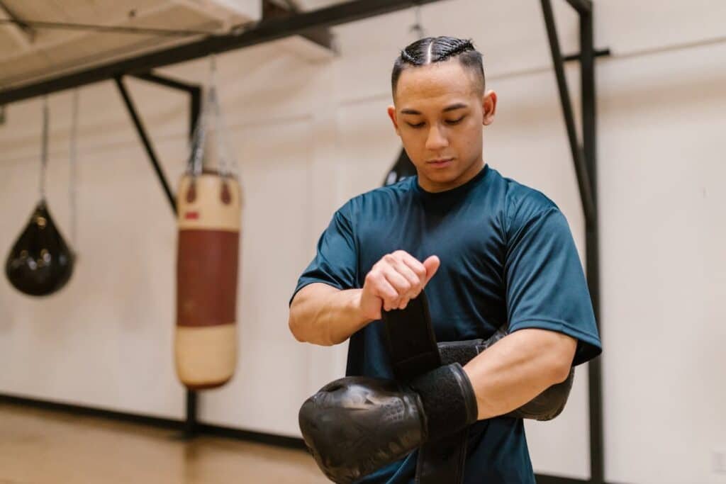 Boxer tightening a set of beginner boxing gloves so they aren't loose