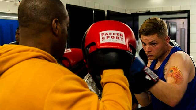 A boxer does frequent pad training with his coach before a boxing fight