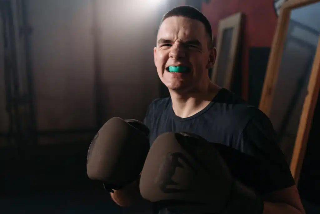 A boxer smiling with his mouthguard in