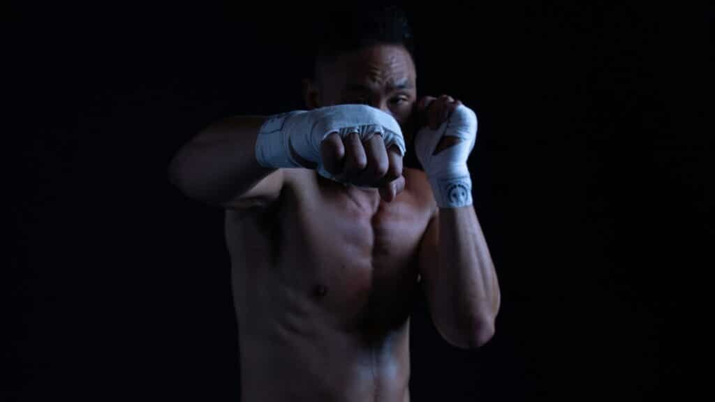 Boxer shadow boxing in a black room
